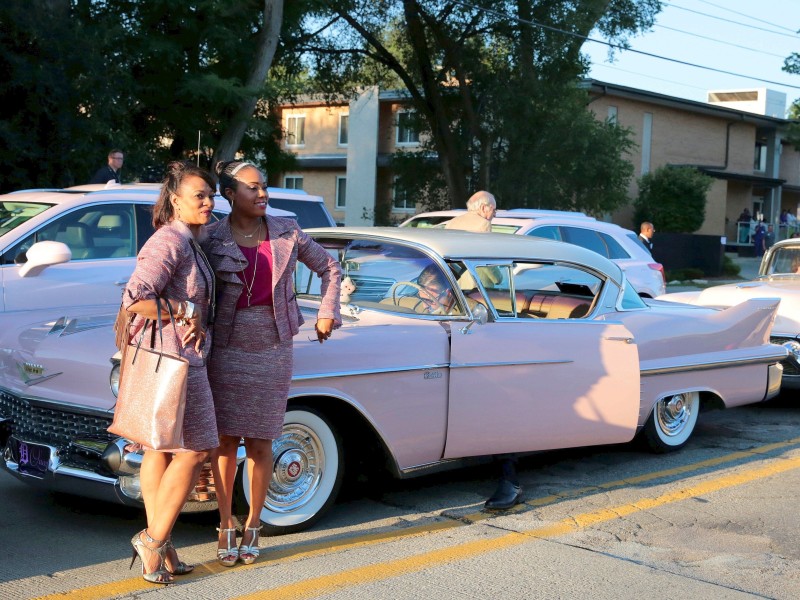 Zwei Frauen posieren vor einem der 100 pinken Cadillacs, die vor dem Greater Grace Temple parkten. 