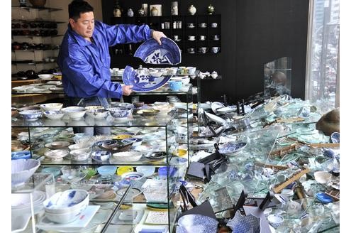 ...der Besitzer eines Keramik-Shops in Tokio begutachtet die Schäden nach dem schweren Erdbeben...