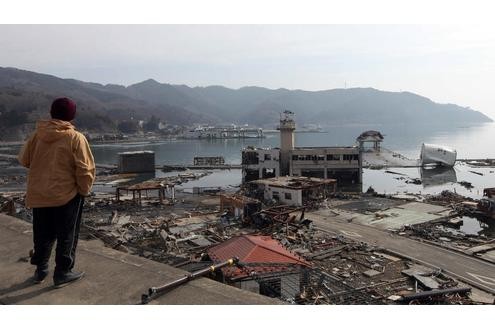 Ein Mann schaut auf den verwüsteten Hafen von Onagawa. Noch ist unklar, wieviel atomare Strahlung durch die zwei Explosionen im Kraftwerk Fukushima freigesetzt hat.