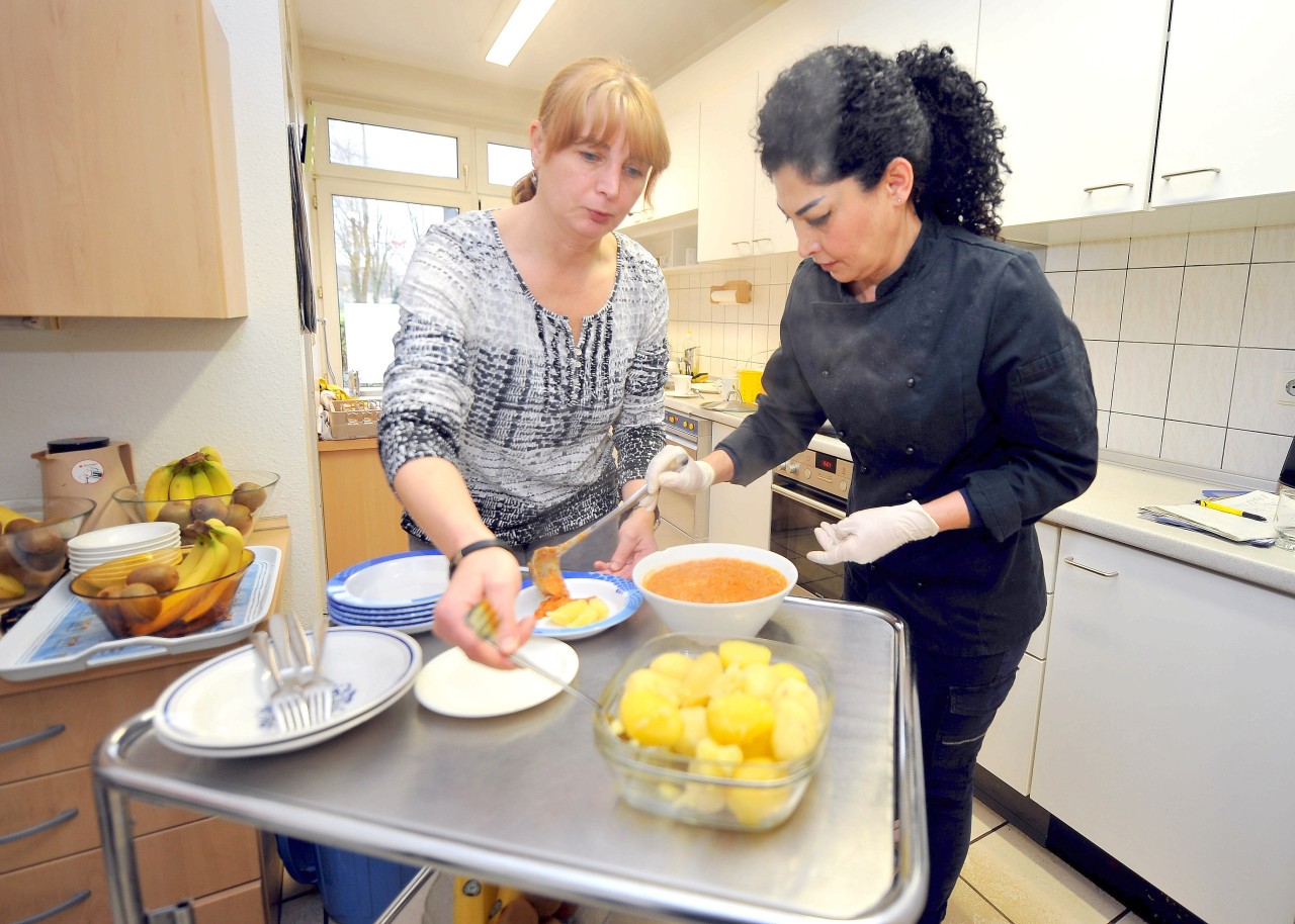 Roya Vakili und Erzieherin Martina Simon (l) füllen das Essen für die U3-Gruppe in Schüsseln.Gleich wird gegessen