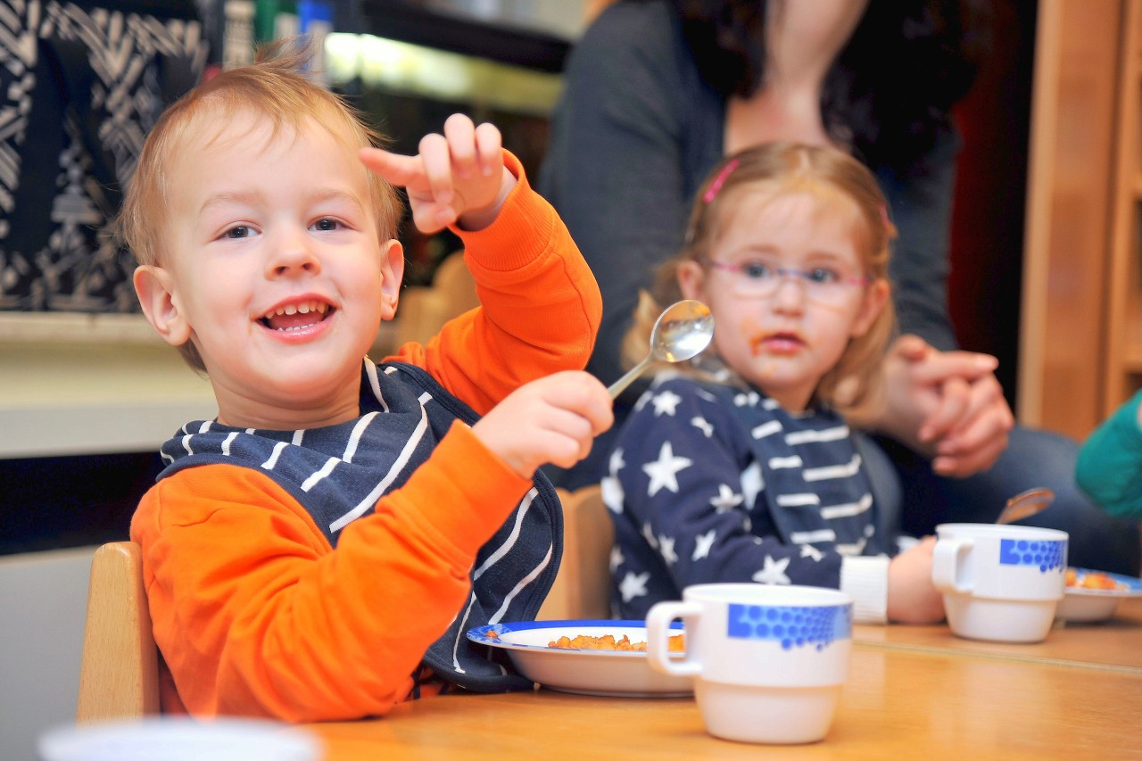 Björn (l.) lässt sich das Essen in seiner U3-Gruppe im Familienzentrum Hl. Familie schmecken. Es gibt Kartoffeln mit Zucchini, Paprika und Hackfleisch.