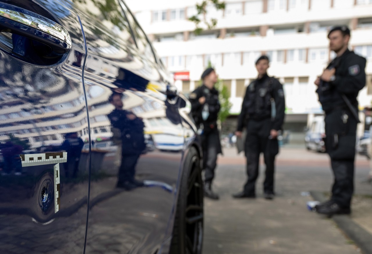 Duisburg: Polizisten sichern nach der Schießerei auf dem Hamborner Altmarkt ein Auto mit Einschusslöchern am Tatort.