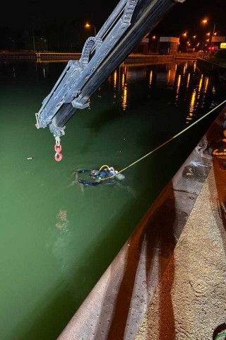 Ein Taucher der Feuerwehr Gelsenkirchen ist im Rhein-Herne-Kanal im Einsatz, um das Fahrzeug zu bergen.