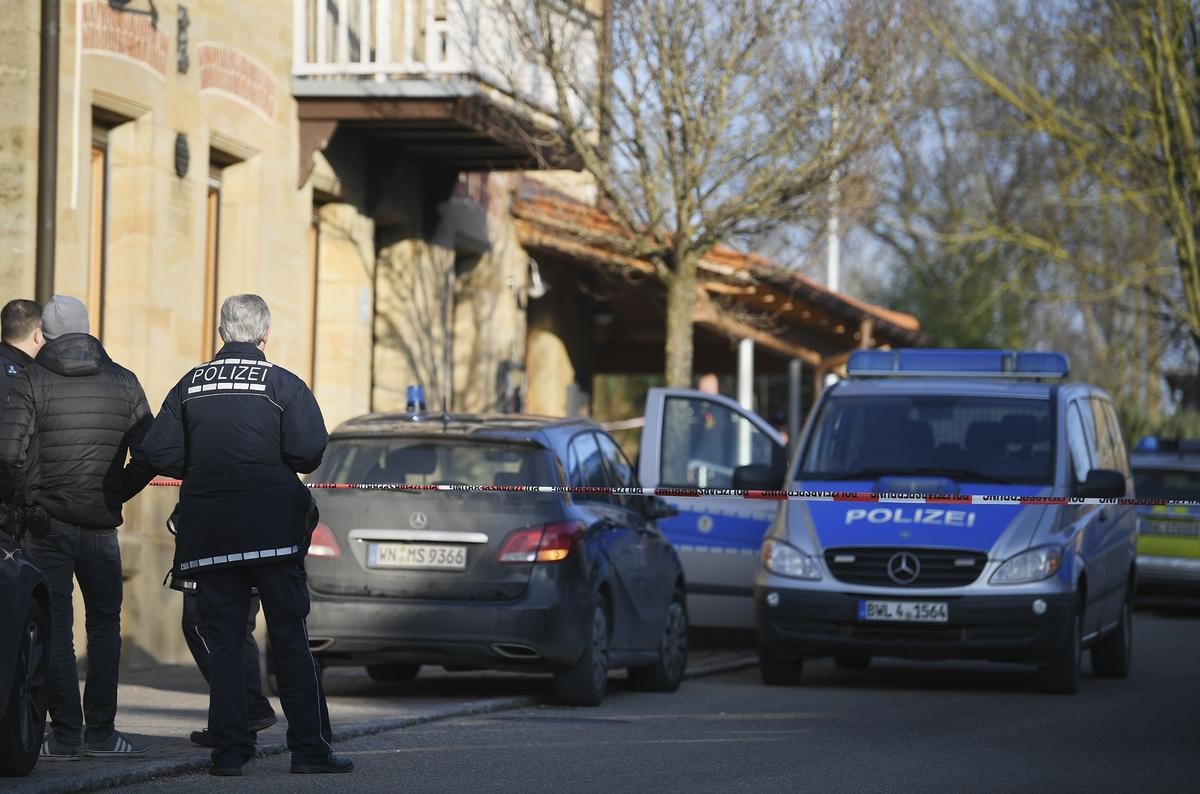 Nach Schüssen in Rot am See im Nordosten Baden-Württembergs stehen Polizeiautos an einem Haus.