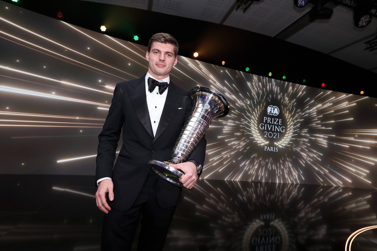 Verstappen posiert mit seiner Trophäe.