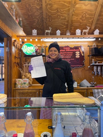 Weihnachtsmarkt Duisburg: Carina Lenz kontrolliert die Kunden bei ihrem „Kartoffeltwister“ stichenprobenartig auf 2G.