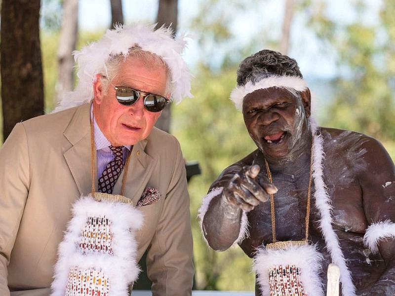 Charles – mit traditionellem Federschmuck auf dem Kopf und um den Hals gehängt – bei einer traditionellen Willkommenszeremonie mit einem Ältesten der indigenen Bevölkerung im australischen Gove. 
