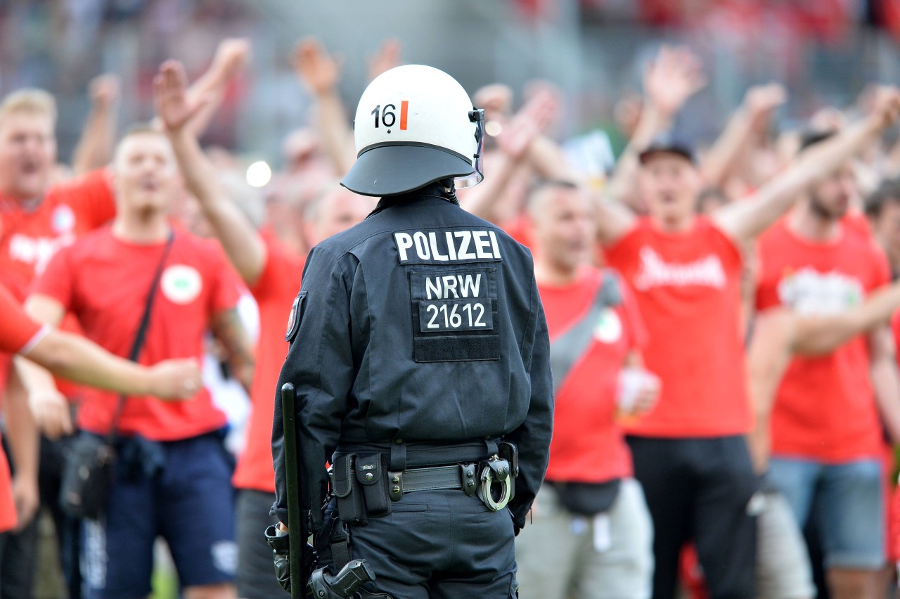 Ein Polizist sichert das Spielfeld beim Platzsturm der RWO-Fans.
