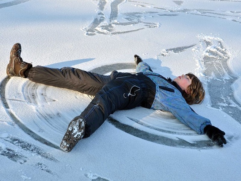 Der kleine Lyubumyr macht in Bislich am Niederrhein einen Schnee-Engel. Anderes Geflügel...