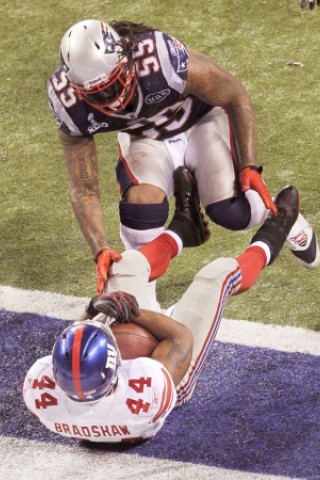 New York Giants running back Ahmad Bradshaw (R) scores the winning touchdown as New England Patriots outside linebacker Brandon Spikes closes in during the NFL Super Bowl XLVI football game in Indianapolis, Indiana, February 5, 2012. REUTERS/John Sommers Ii (UNITED STATES  - Tags: SPORT FOOTBALL)