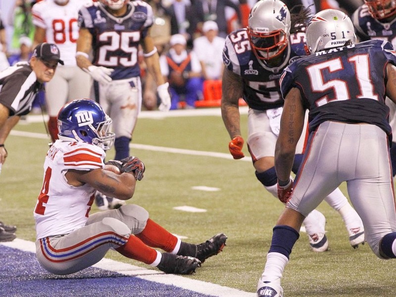 New York Giants running back Ahmad Bradshaw (L)  comes in to score the winning touchdown as New England Patriots outside linebacker Brandon Spikes  and Jerod Mayo (R) watch  in the NFL Super Bowl XLVI football game in Indianapolis, Indiana, February 5, 2012. REUTERS/Mike Segar (UNITED STATES  - Tags: SPORT FOOTBALL)