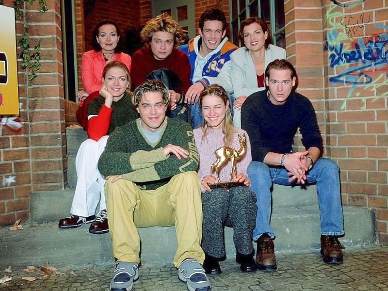 Nadine Dehmel, Tim Sander, Jan Hartmann, Cathrin Vaessen (o.v.li.), Nina Bott (2.R. li.), Raphael Vogt, Rhea Harder und Patrick Harzig freuen sich 1999 über die Bambi-Auszeichnung für GZSZ.