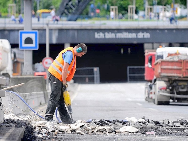 Ohrenschützer sollen helfen, den Lärm der Presslufthämmer besser zu ertragen. Hier beackert ein Arbeiter die Fahrbahndecke vor dem A40-Tunnel im Zentrum von Essen.Foto: Kerstin Kokoska/WAZ  FotoPoolEssen