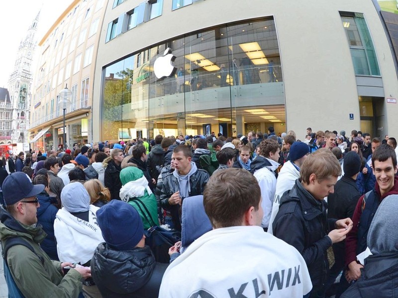 Customers queue to enter the Apple Store where a giant logo is displayed in the southern German city of Munich on September 21, 2012 as the iPhone 5 goes on sale. AFP PHOTO/CHRISTOF STACHE