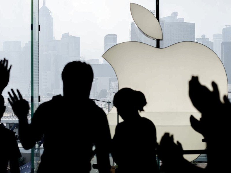 TOPSHOTS  A customer (L) is greeted by Apple employees as she enters the Hong Kong Apple store to get an iPhone 5 on September 21, 2012.  Apple's iPhone 5 hit stores in Hong Kong with queues of devotees undeterred by a lukewarm welcome from experts for the smartphone and complaints about its new mapping system. AFP PHOTO / Philippe Lopez