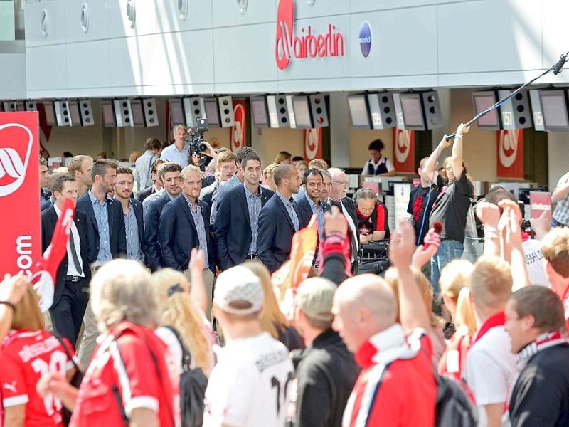 Die Mannschaft der Fortuna wird darin auf dem Weg zum Schalter von einer Gruppe Fans besungen.