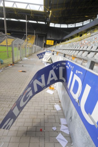 Am Tag nach dem Pokalspiel zwischen Borussia Dortmund und Dynamo Dresden zeigen sich die Schäden am Gästeblock: zerstörte Werbebanden, angekokelte Fahnen und Reste von Pyrotechnik.