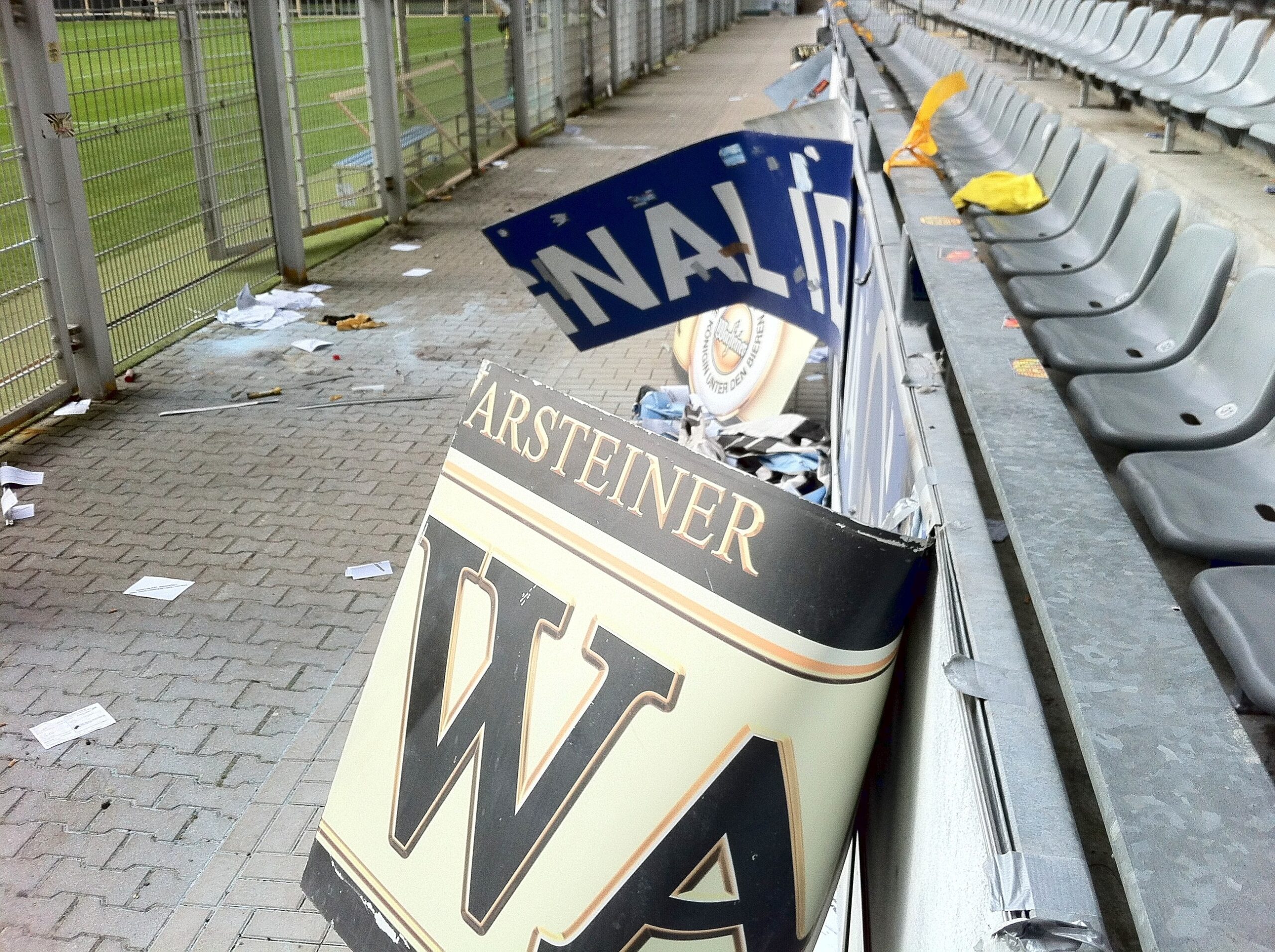 Am Tag nach dem Pokalspiel zwischen Borussia Dortmund und Dynamo Dresden zeigen sich die Schäden am Gästeblock: zerstörte Werbebanden, angekokelte Fahnen und Reste von Pyrotechnik.