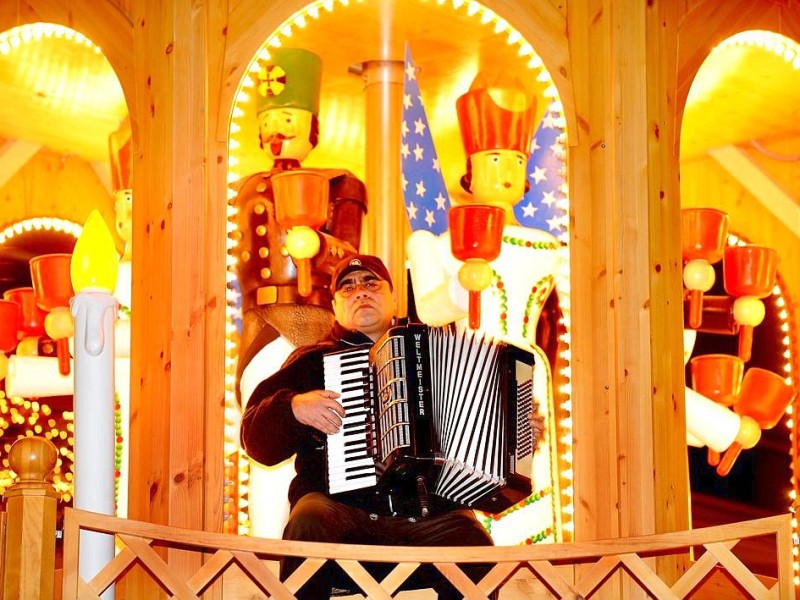 Am Samstag, den 19.11.2011 strömen tausende Besucher am ersten Wochenende auf den Weihnachtsmarkt in Duisburg - Mitte. Bei trockenem kühlen Wetter geniessen die Leute Glühwein , Leckereien oder kaufen schon mal das ein oder andere Geschenk für Weihnachten. Auf der Weihnachtspyramide spielt ein Mann festliche Musik Foto: Stephan Eickershoff / WAZ FotoPool