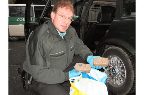Ein Zollbeamter entdeckt mehrere Päckchen Haschisch. Foto: Zoll 