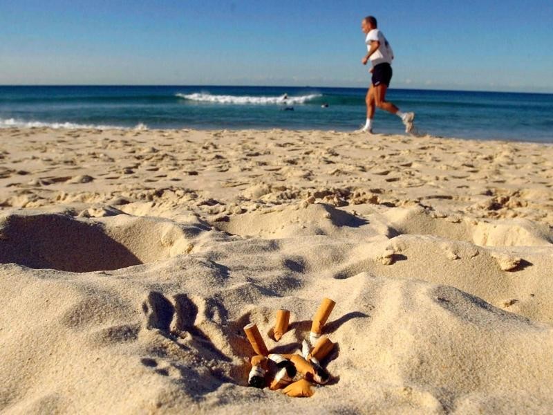 Ausgedrückte Zigarettenstummel gehören in den Aschenbecher - nicht in den Sand.