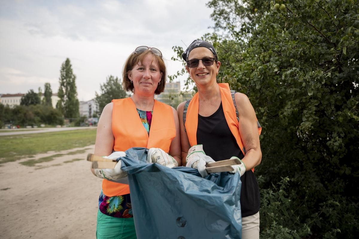 Nicky Jenkins (l) und Jo Tuna, beide Touristinnen aus England, stehen bei einer Stadttour mit Müllsammeln im Mauerpark.