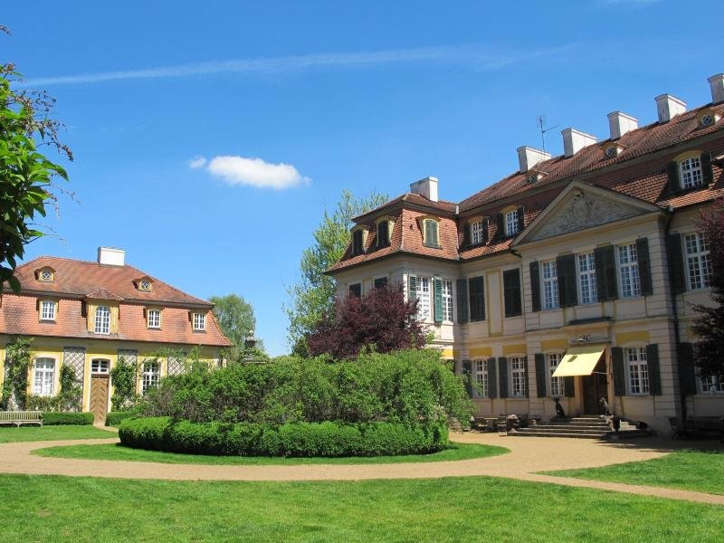 Das barocke Schlossgebäude bildet vor dem blauen Himmel und dem gepflegten Grün einen schönen Kontrast.