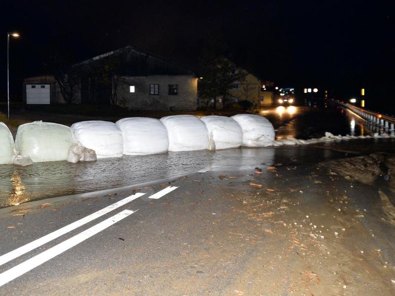 Eingepackte Heuballen und Sandsäcke liegen als Barriere gegen Wasser und Schlamm auf der Brenner-Bundesstraße.