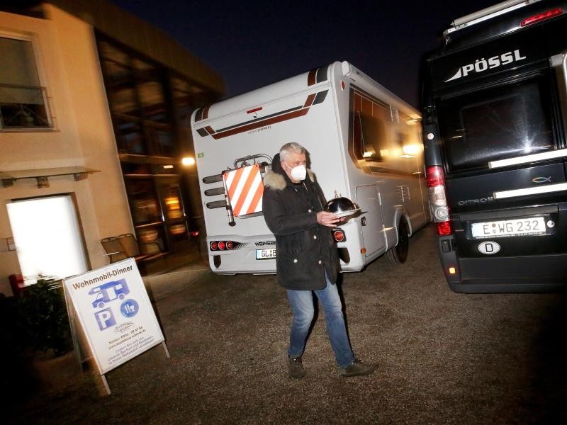 Hans-Werner Scherer, Gastwirt des Restaurantes "Bootshaus Ruhreck", bringt seinen Kunden Dorothea und Hubert eine Vorspeise zu ihrem Wohnmobil.