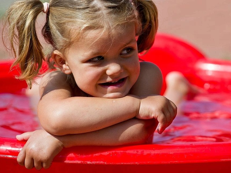 Die dreijährige Mia planscht in Sieversdorf bei Temperaturen um die 30 Grad Celsius in einem kleinen Wasserbecken.