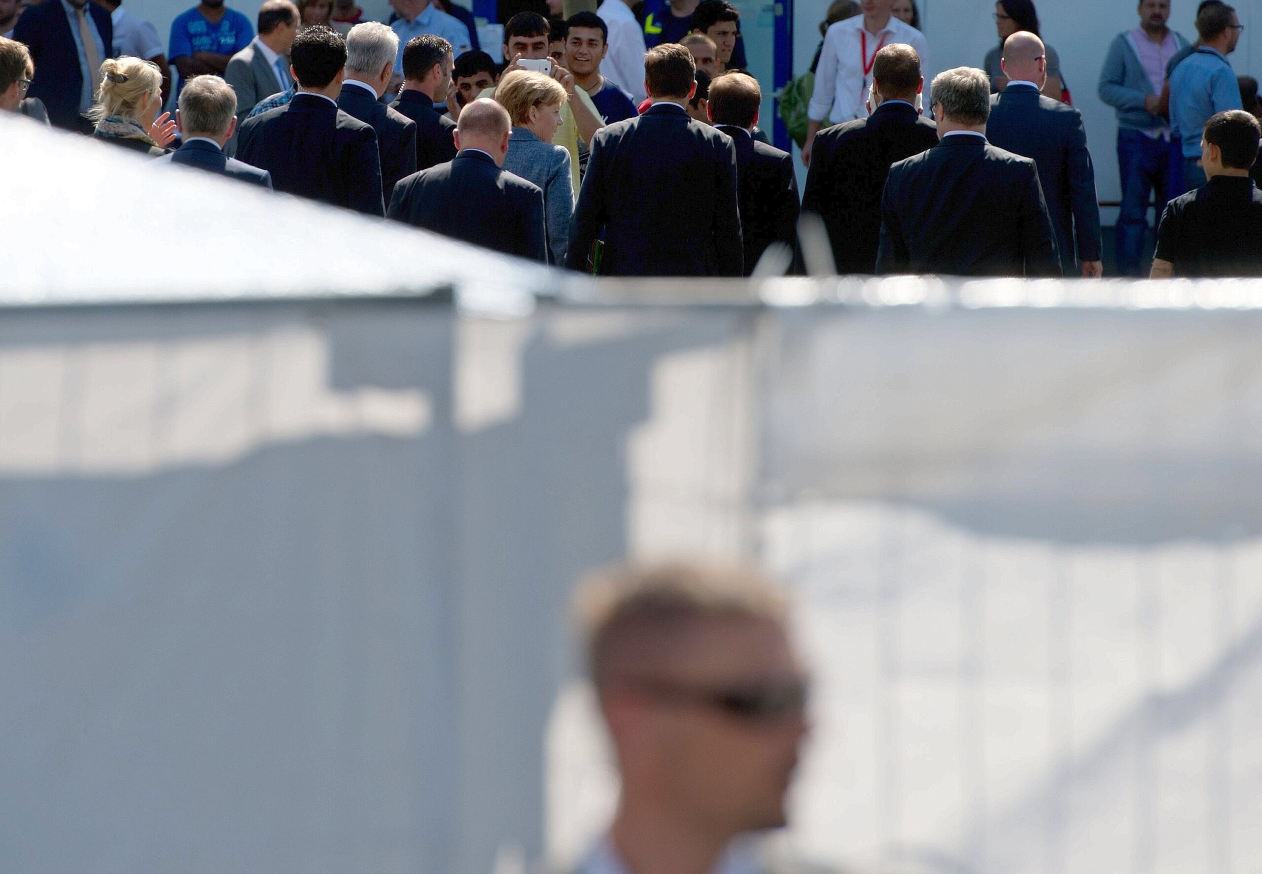 Umringt von Flüchtlingen und DRK-Funktionären besucht Bundeskanzlerin Angela Merkel gemeinsam mit Sachsens Ministerpräsident Stanislaw Tillich und weiteren Mitgliedern der Landesregierung die Flüchtlingsunterkunft in Heidenau.