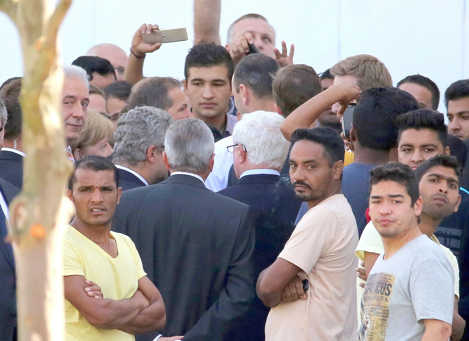 Umringt von Flüchtlingen und DRK-Funktionären besucht Bundeskanzlerin Angela Merkel gemeinsam mit Sachsens Ministerpräsident Stanislaw Tillich und weiteren Mitgliedern der Landesregierung die Flüchtlingsunterkunft in Heidenau.