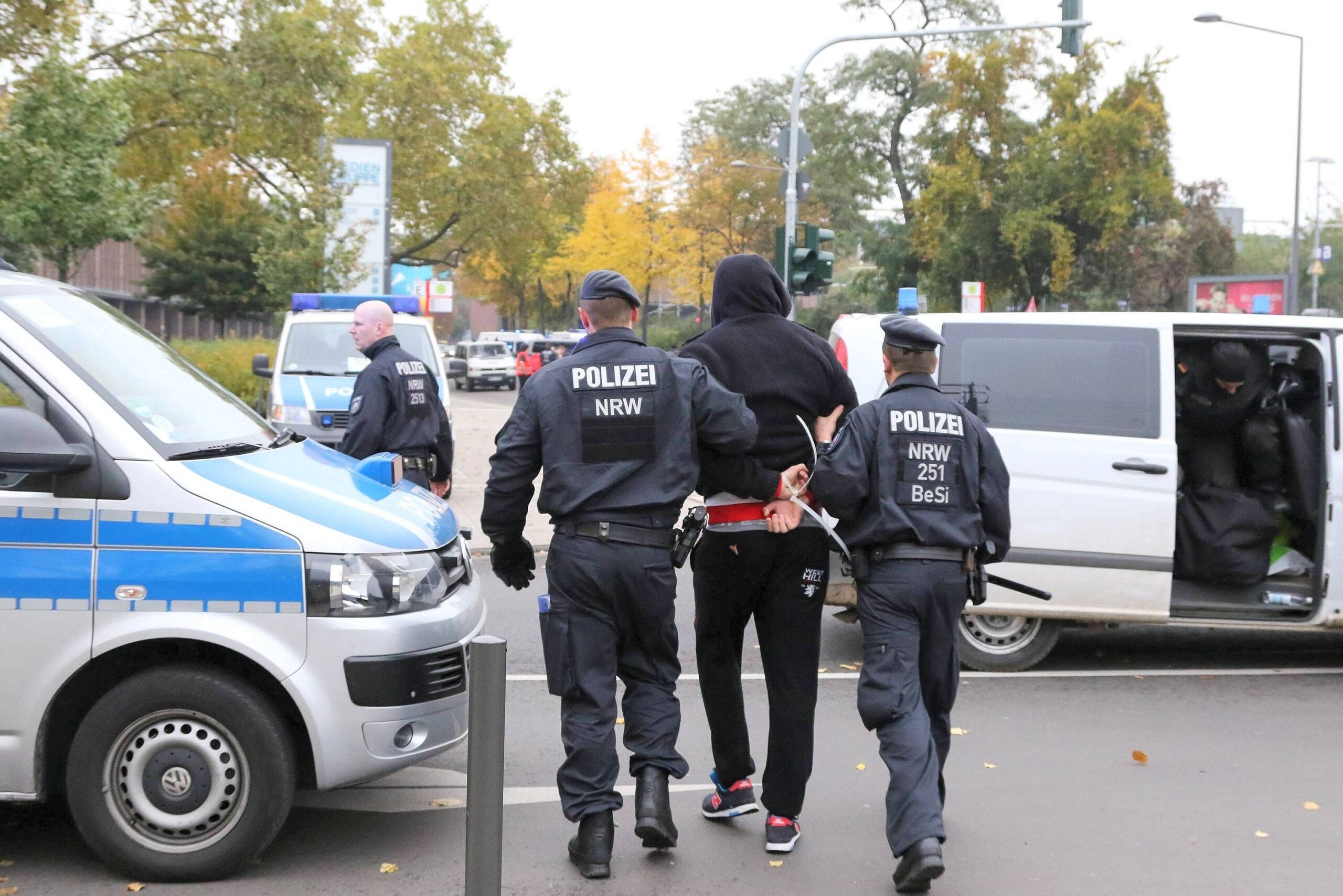 Ein Demonstrant wird von zwei Polizisten abgeführt.