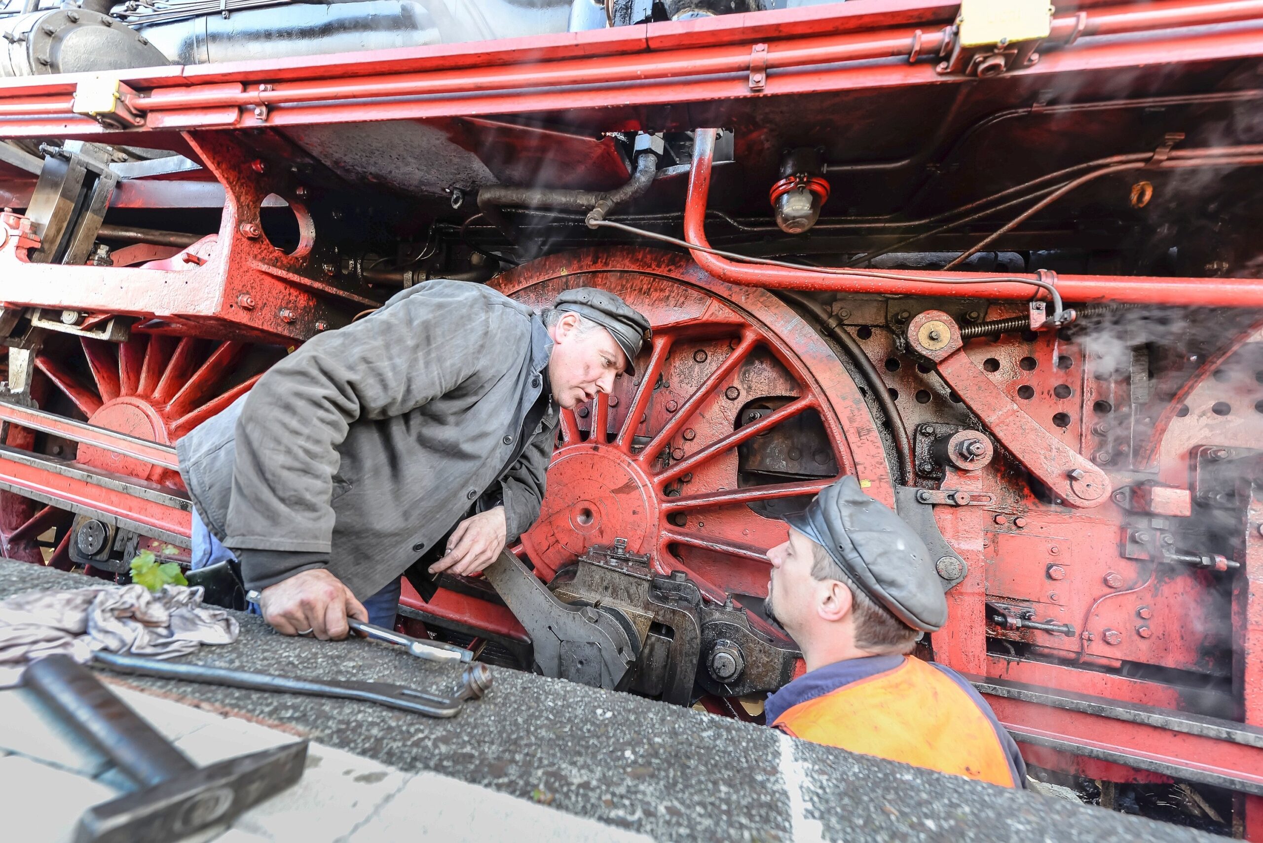 Während eines Stopps warten und reparieren Heizer Volker Böhm und Lokführer Christian Harzendorf die Antriebsmechanik.