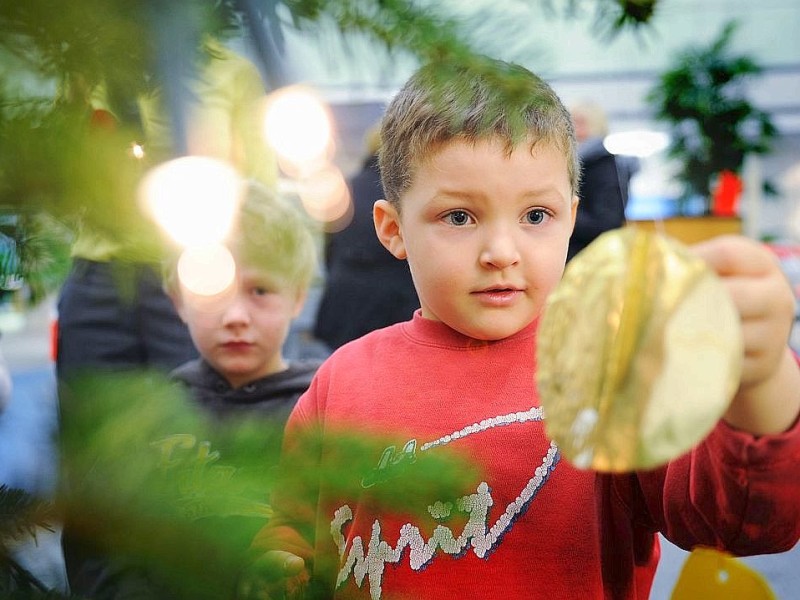 Am 18.11.2011 findet in Moers die Weihnachtswunschbaumaktion der NRZ/WAZ in Zusammenarbeit mit dem Verein Klartext für Kinder e.V. statt. Kiunder der Kindergärten aus der Region hängen Wunschzettel an Weihnachtsbäume in den Räumlichkeiten von Geldinstituten und des Einzelhandels. Im Bild: ein Junge schmückt einen Weihnachtsbaum.Foto: Matthias Graben / WAZ FotoPool