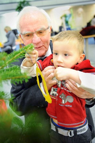 Am 18.11.2011 findet in Moers die Weihnachtswunschbaumaktion der NRZ/WAZ in Zusammenarbeit mit dem Verein Klartext für Kinder e.V. statt. Kiunder der Kindergärten aus der Region hängen Wunschzettel an Weihnachtsbäume in den Räumlichkeiten von Geldinstituten und des Einzelhandels. Im Bild: Hans-Dieter Wichert vom Verein Klartext für Kinder und Philipp schmücken einen Weihnachtsbaum.Foto: Matthias Graben / WAZ FotoPool