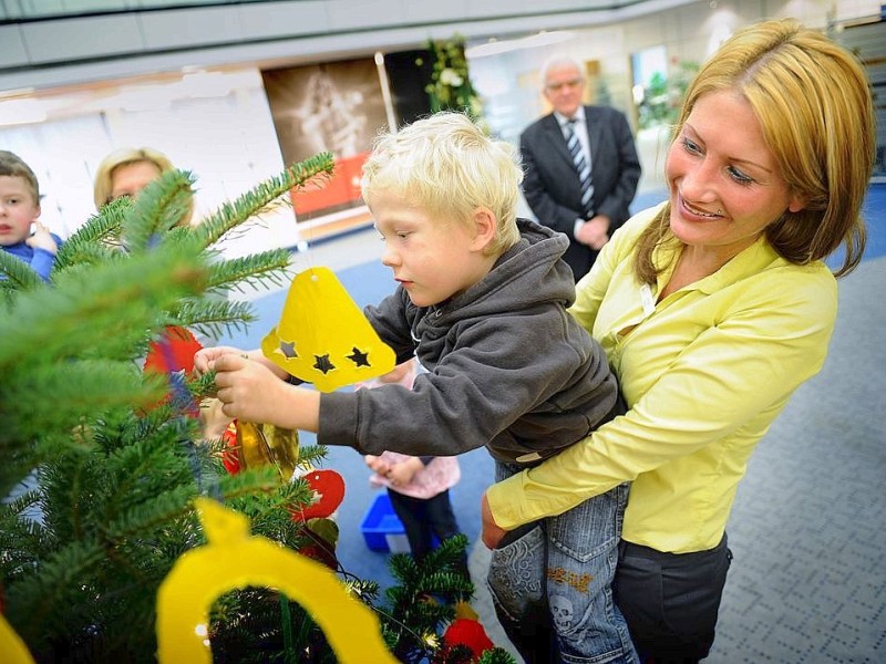 Am 18.11.2011 findet in Moers die Weihnachtswunschbaumaktion der NRZ/WAZ in Zusammenarbeit mit dem Verein Klartext für Kinder e.V. statt. Kiunder der Kindergärten aus der Region hängen Wunschzettel an Weihnachtsbäume in den Räumlichkeiten von Geldinstituten und des Einzelhandels. Im Bild: Olga Holz hilft Maurice beim Schmücken des Weihnachtsbaumes.Foto: Matthias Graben / WAZ FotoPool