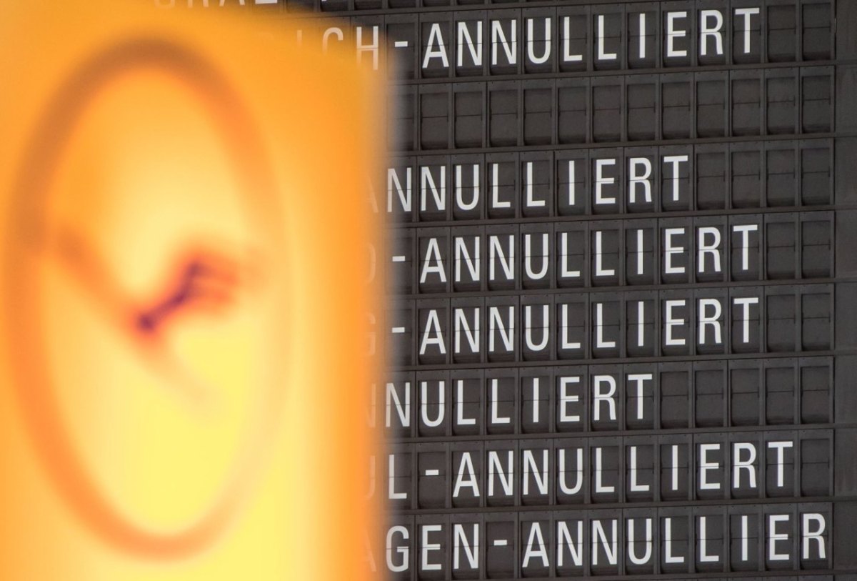 Das Lufthansalogo vor einer Anzeigetafel