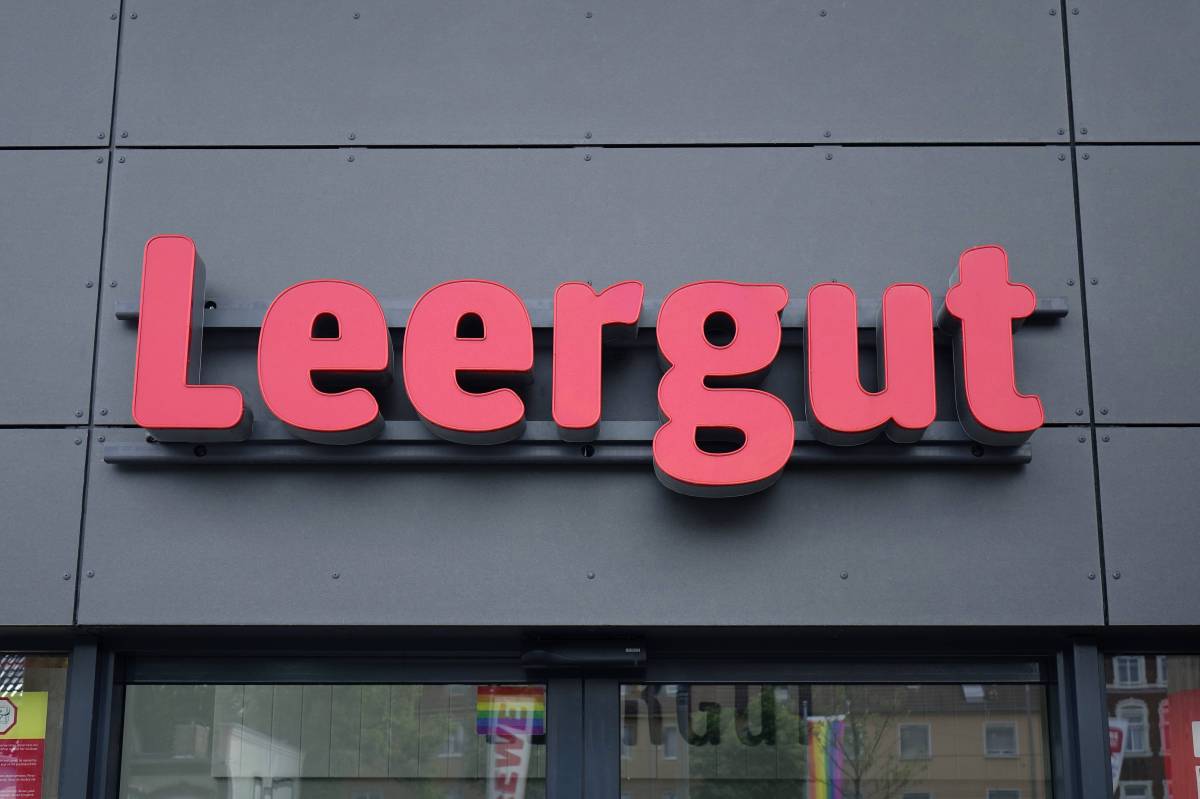 Das Wort "Leergut" in roten Buchstaben auf der grauen Fassade einer Rewe-Filiale.