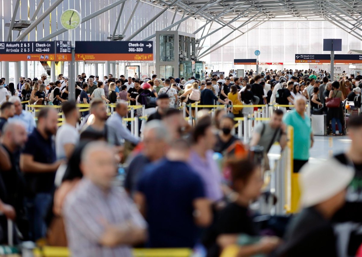 Am Flughafen drängen sich die Reisenden dicht an dicht.