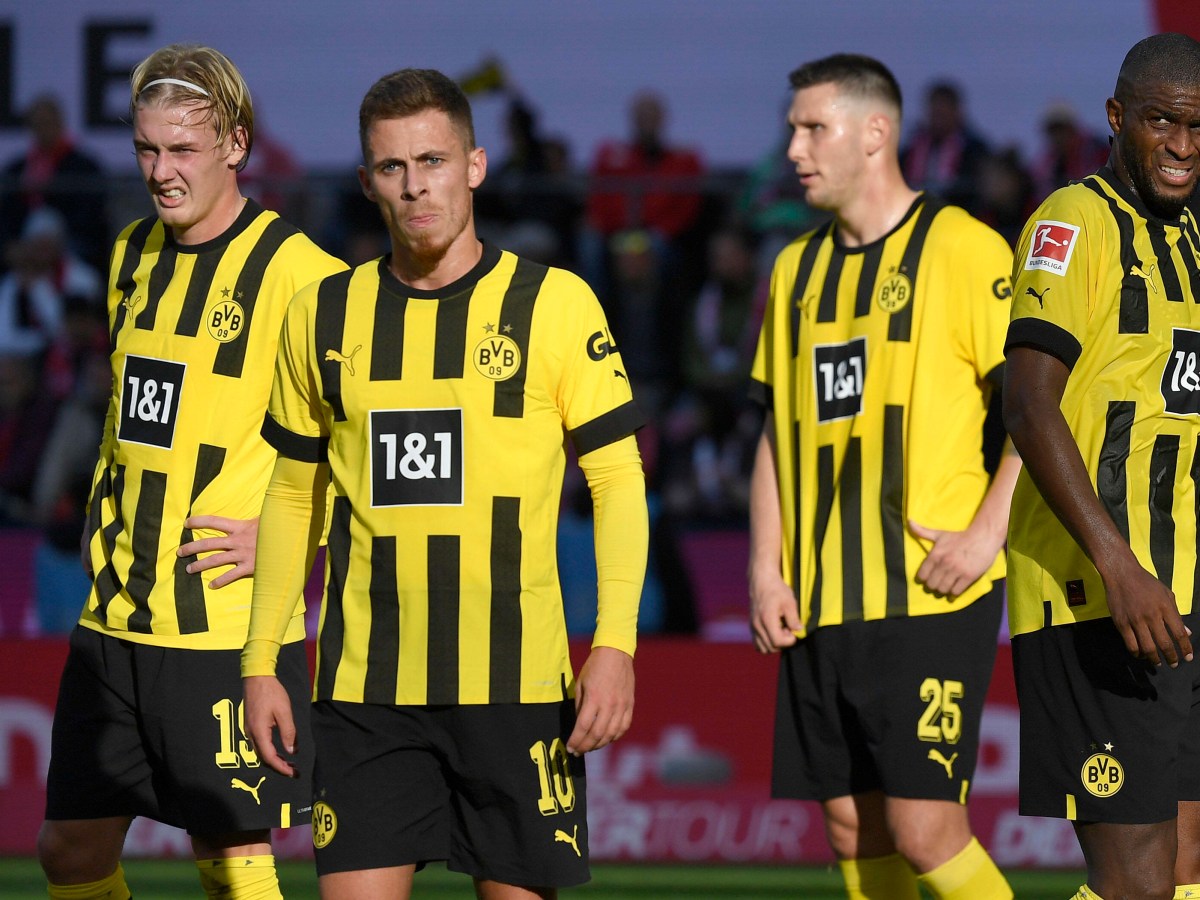 Vier Spieler von Borussia Dortmund stehen auf dem Platz.