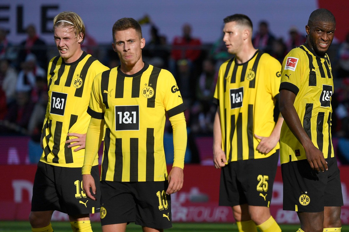 Vier Spieler von Borussia Dortmund stehen auf dem Platz.