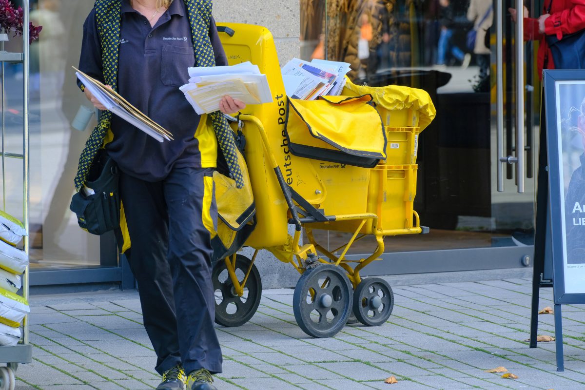 Deutsche Post: Briefträger teilt Post aus.