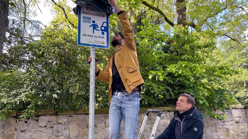 Mann stellt Schild auf