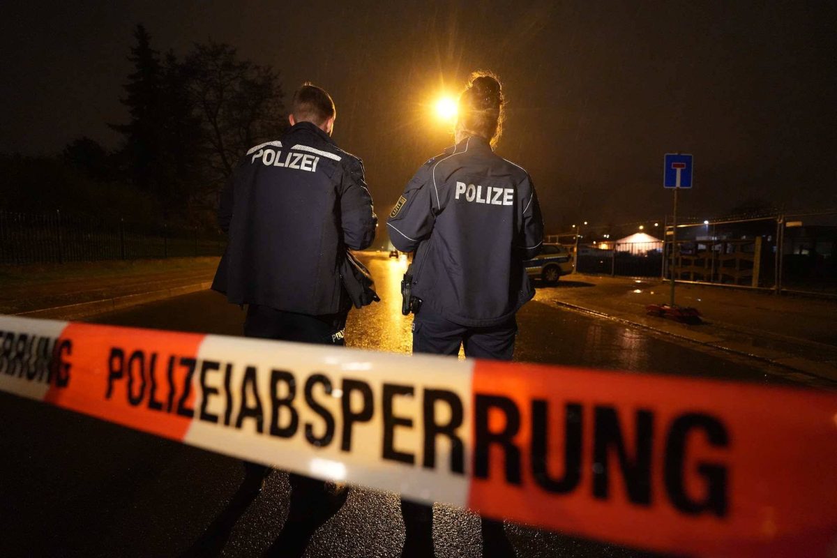 Polzeiabsperrband und Polizisten auf Straße