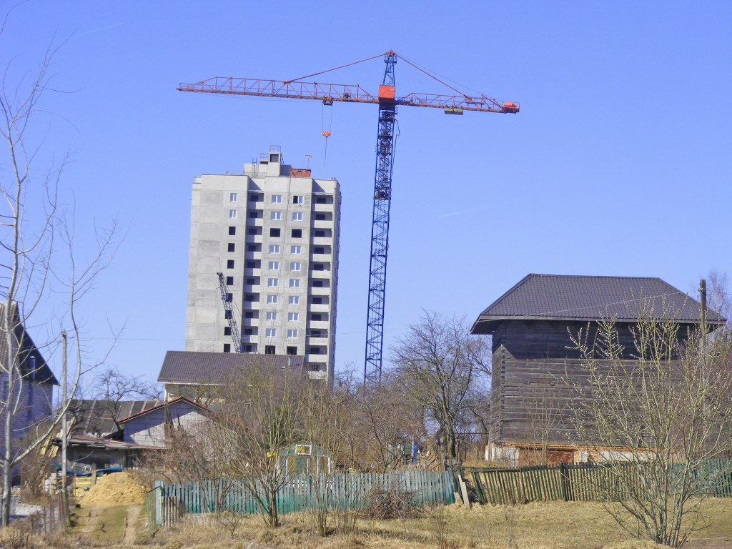 Ein Kran steht neben einem grauen Hochhaus in Minsk.