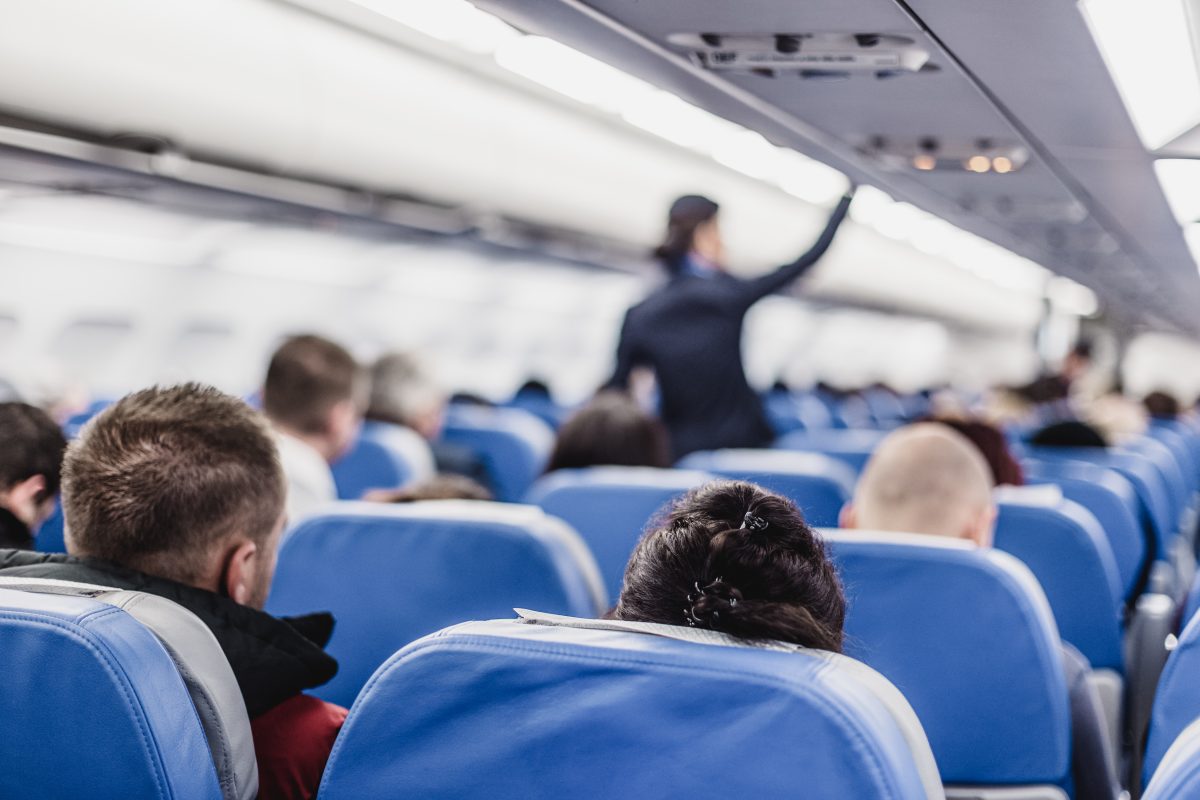 Passagiere und Stewardess im Flugzeug