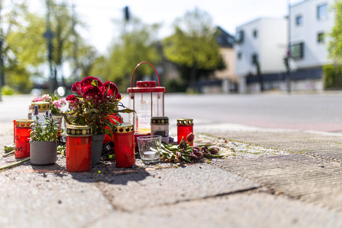 Trauerstelle an einer Straße mit Blumen und Kerzen