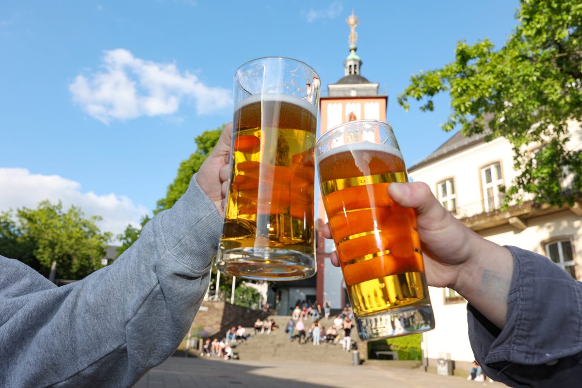 Zwei stoßen mit einem Glas Bier an