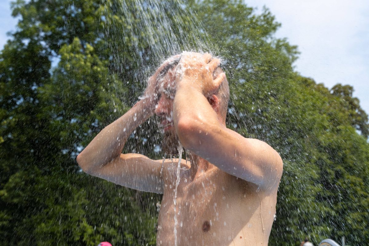 Mann duscht sich im Freibad